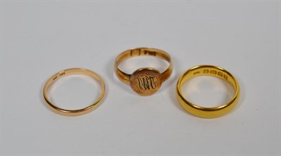 Lot 267 - A 22 carat gold band ring, finger size L1/2, a band ring stamped '585', finger size O, and a signet