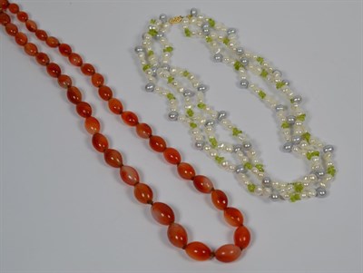 Lot 282 - A peridot and cultured pearl necklace, clasp stamped '14K', length 46cm, and a cornelian bead...