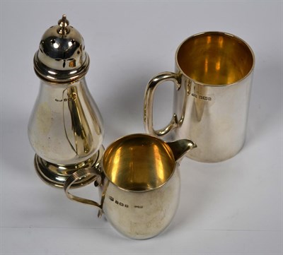 Lot 339 - A silver mug, Sheffield, a silver caster by Deakin and Francis, Birmingham, and a silver cream jug