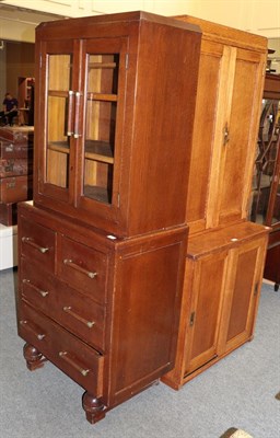 Lot 1211 - An oak bookcase, the upper section with hinged twin panelled doors, above a lower section...