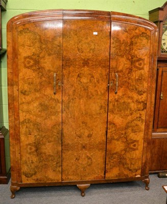 Lot 1253 - An Art Deco figured walnut three door wardrobe, with a fitted interior