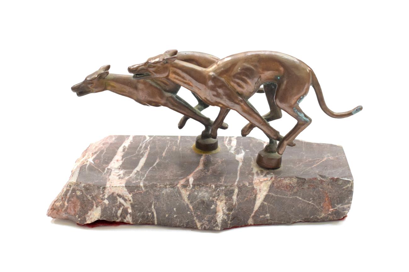 Lot 3006 - Two Early 20th Century Bronze Car Mascots, in the form of greyhounds, mounted on a pink marble...