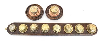 Lot 3183 - Eight Early 20th Century Brass Hub Spinners, mounted on an oak plaque, to include: Bristol...