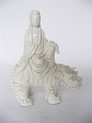 Lot 133 - A Blanc de Chine Figure of Guanyin, Qing Dynasty, the robed figure sitting on the back of a...