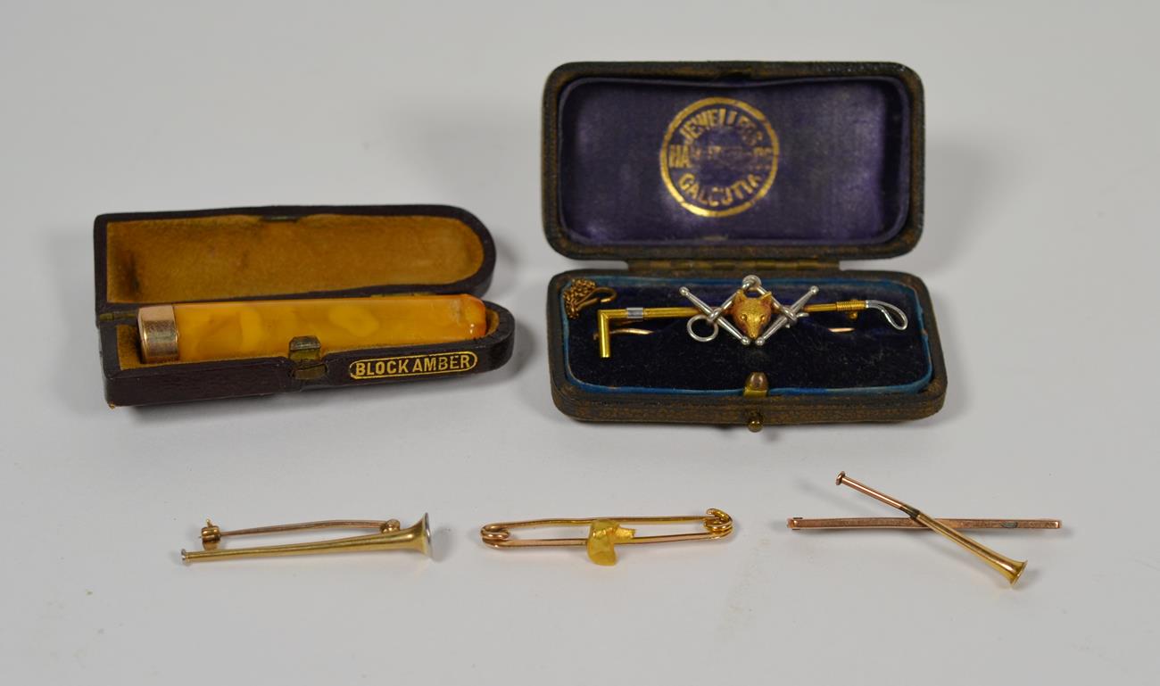 Lot 52 - Four stock pins, one cased; and an amber cheroot holder with 9 carat gold mount, in fitted case (5)