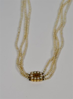 Lot 54 - A three strand seed pearl necklace, with a yellow stone and seed pearl clasp, length 90cm