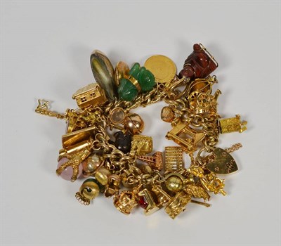 Lot 79 - A charm bracelet, each link stamped '9' '.375', hung with approximately fifty charms, including...