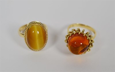 Lot 82 - A 9 carat gold tigers-eye ring, finger size O1/2; and an amber ring, stamped '9CT', finger size...