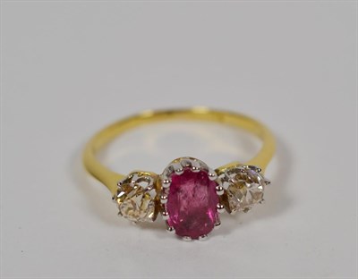 Lot 103 - A ruby and diamond ring, an oval mixed cut ruby flanked by two old cut diamonds in white claw...