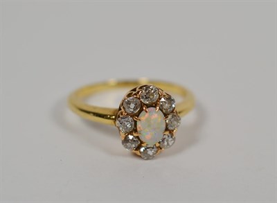 Lot 104 - An opal and diamond cluster ring, total estimated diamond weight 0.40 carat approximately,...