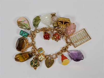 Lot 179 - A 9 carat gold charm bracelet, hung with seventeen charms, including a coral Buddha, a turquoise, a