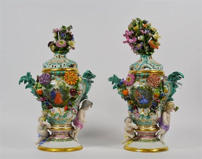 Lot 216 - A pair of 19th century Dresden floral encrusted pedestal vases and covers, painted with panels...