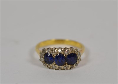 Lot 336 - A sapphire and diamond triple cluster ring, stamped '18CT', finger size N