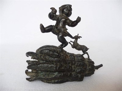 Lot 189 - A Chinese Bronze Figure of a Child, late 19th/20th century, being chased by a goat on a finger...