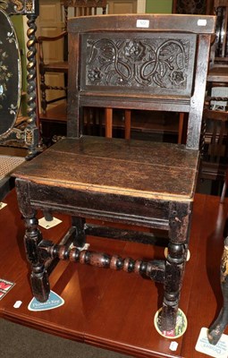 Lot 522 - A 17th century and later oak chair with floral carved panel back