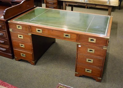 Lot 527 - A mahogany reproduction campaign style pedestal desk with green leather top