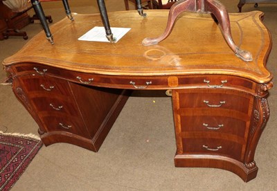 Lot 573 - A George III style mahogany and crossbanded library desk, modern, the serpentine shaped top inset a