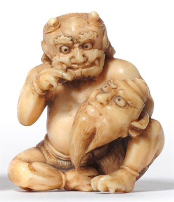 Lot 205 - A Japanese Carved Ivory Oni Netsuke, circa 1880, the seated demon pointing with amusement at...