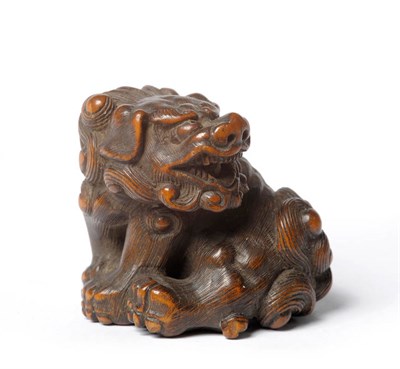 Lot 217 - A Japanese Carved Wood Netsuke as a Shi-Shi, 19th century, the muscular beast seated on its...