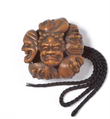 Lot 218 - A Japanese Carved Pierced Wood Netsuke as a Cluster of Kabuki Masks, 19th century, each of...