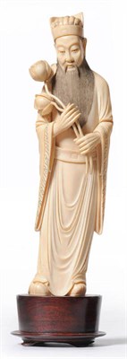 Lot 223 - A Chinese One Piece Carved Elephant Ivory Figure of Guanyin, circa 1930, the slender enrobed...