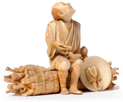 Lot 238 - A Japanese Carved Elephant Ivory Figure of a Woodman, circa 1890, seated smoking a pipe on a...