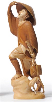 Lot 244 - A Japanese Carved Ivory Figure of a Traveller, circa 1930, wearing a basket moulded hat,...