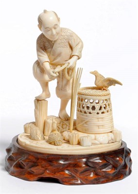 Lot 245 - A Japanese Carved Ivory Figure of a Hunter, Meiji period (1868-1912), standing beside a pool...