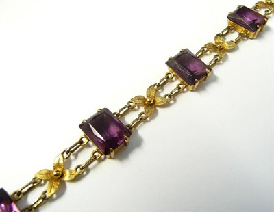 Lot 262 - An Bracelet Set with Purple Paste Stones, six scissor cut stones chain linked and alternated with a