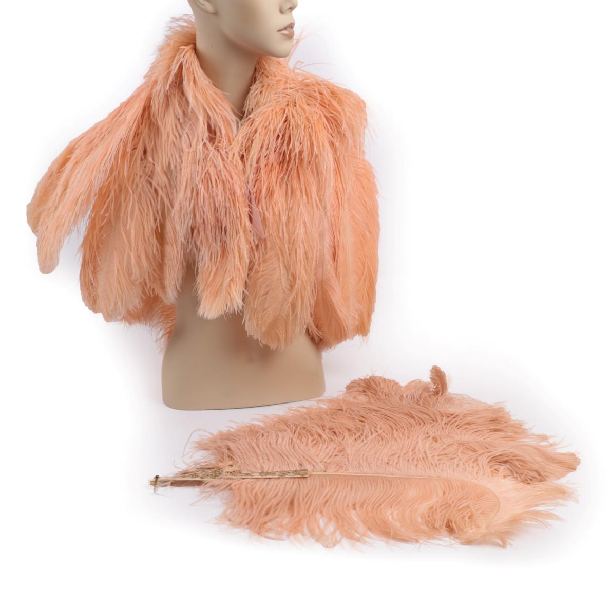 Lot 2040 - An Early 20th Century Peachy/Pink Ostrich Feather Fan and Matching Feather Cape, the fan...