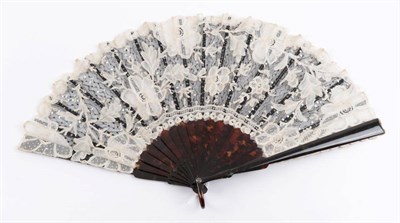 Lot 2125 - A Tortoiseshell Fan, circa 1900, mounted with a leaf of black net, applied white Brussels...
