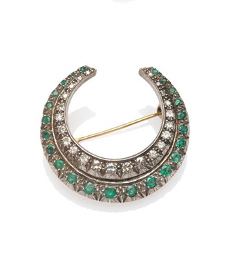 Lot 285 - An Emerald and Diamond Crescent Brooch, a row of graduated emeralds with an inner row of...