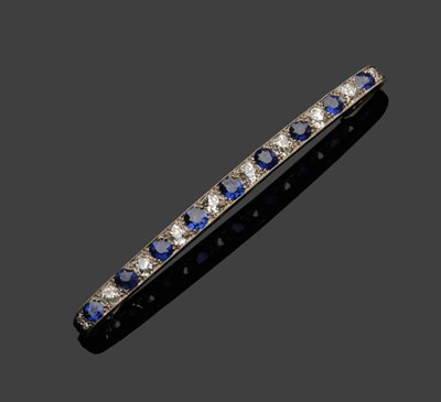 Lot 305 - A Sapphire and Diamond Bar Brooch, the slightly graduated old cut stones alternate, total estimated