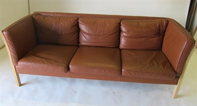 Lot 3654 - Stouby: A Beech Framed Three-Seater Sofa, upholstered in brown leather, with eight removable...
