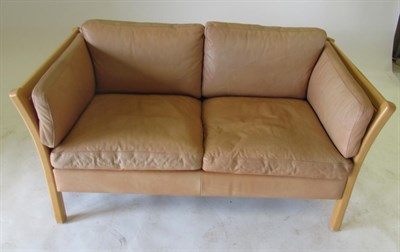 Lot 3655 - Stouby: A Danish Design Beech Framed Two-Seater Sofa, covered in light brown tan leather, with...