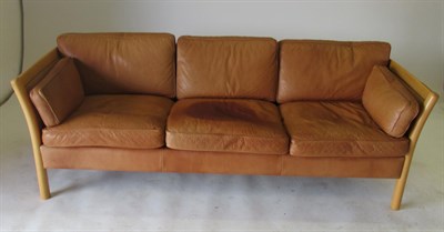 Lot 3656 - Stouby: A Danish Design Beech Framed Three-Seater Sofa, covered in tan leather, with eight...