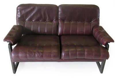 Lot 3660 - A Danish Design Stained Beech Two-Seater Sofa, covered in red/brown leather with buttoned back...