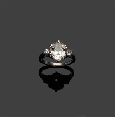 Lot 331 - A Diamond Three Stone Ring, an old oval cut diamond is flanked by a round brilliant cut diamond...