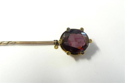 Lot 339 - A Garnet and Diamond Stick Pin, an oval cut garnet held in rose cut diamond set claws, on a pin