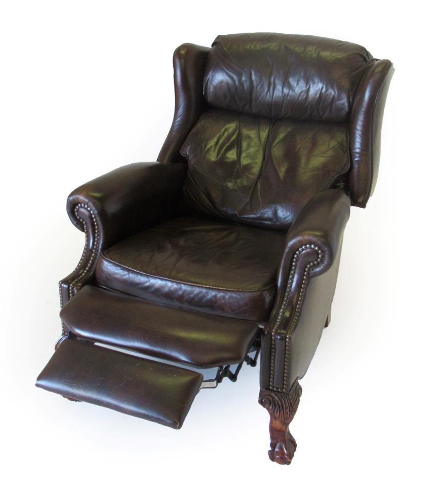 Lot 1015 - A Brown Leather and Close-Nailed Reclining Armchair, modern, with rounded arms above a pivoting...