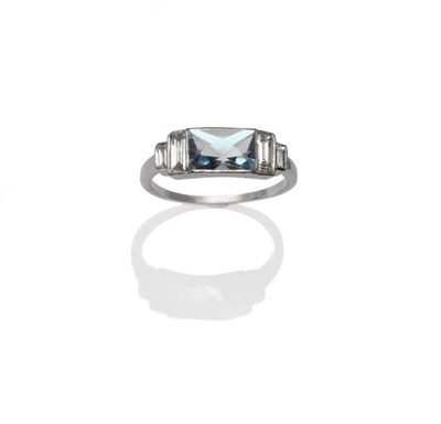 Lot 344 - An Aquamarine and Diamond Ring, the scissor cut aquamarine flanked by graduated baguette cut...