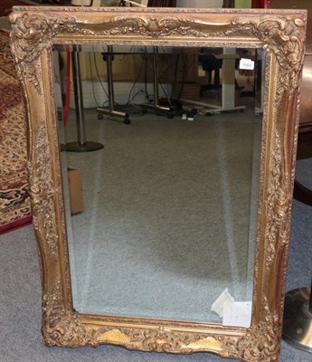 Lot 1060 - A Reproduction Gilt Mirror, with an ornate swept frame, 111cm by 80cm