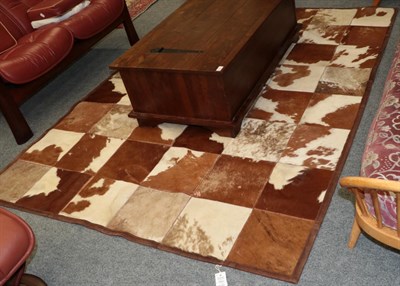 Lot 1076 - Hides/Skins: A Large Patchwork Cow Hide Rug, modern, constructed with square sections of cow...