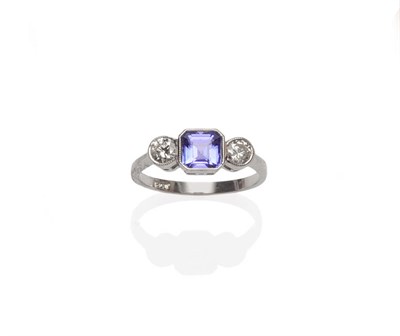 Lot 346 - A Tanzanite and Diamond Three Stone Ring, an octagonal step cut tanzanite flanked by a round...