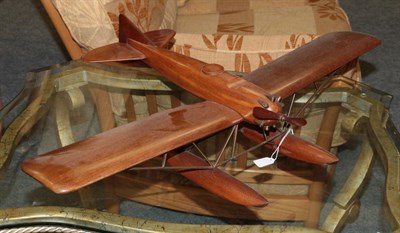 Lot 1080 - A Mahogany Model In The Form Of A 1930's Aeroplane, with pivoting propeller, the wings joined...