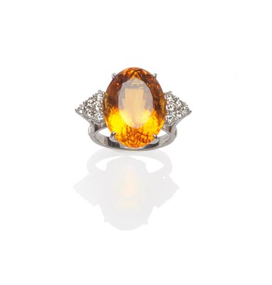 Lot 347 - An 18 Carat White Gold Citrine and Diamond Ring, an oval cut citrine flanked by a cluster of...