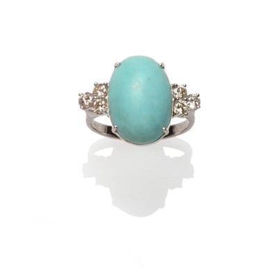 Lot 350 - A 14 Carat White Gold Turquoise and Diamond Ring, an oval cabochon turquoise flanked by a trio...