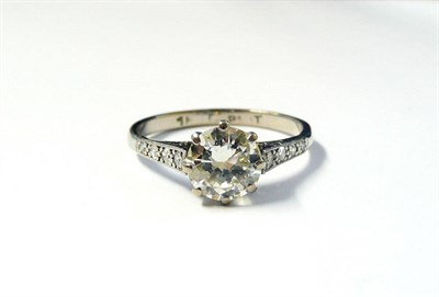 Lot 355 - A Diamond Solitaire Ring with Diamond Set Shoulders, the round brilliant cut diamond in a white...