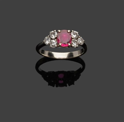 Lot 361 - A Ruby and Diamond Ring, an oval cut ruby flanked by a trio of round brilliant cut diamonds to each