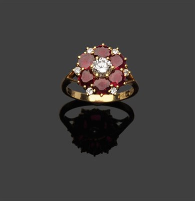 Lot 362 - An 18 Carat Gold Diamond and Ruby Cluster Ring, a round brilliant cut diamond within a border...